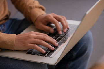 Fototapeta premium Close up hand Asian man on laptop, writing, taking notes,participating in internet class, motivated positive student studying online at home.