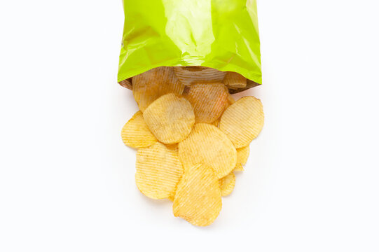 High angle shot of a heap of wavy potato chips on white background