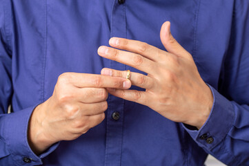 Hands of latin male who is about to taking off his wedding ring