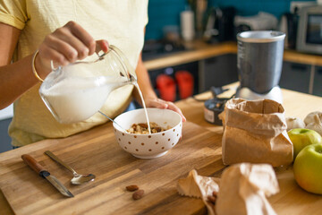 Adding milk to cereals bowl