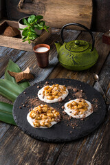 On the serving board is a gourmet dessert green hemisphere with chocolate chips. On a wooden table...