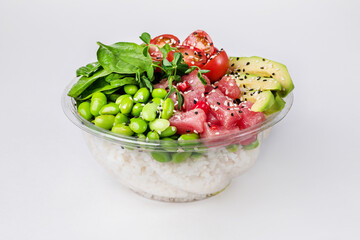 Poke bowl with rice, tuna, edamame beans, avocado, cherry tomatoes and spinach on a white background. Close up