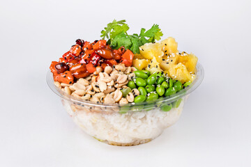 Poke bowl with rice, salmon, edamame beans, parsley, pineapple and peanuts on a white background. Plastic tableware for delivery. Close up.