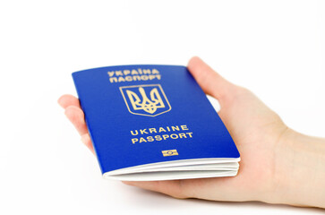Ukrainian passport in a female hand on a white background, selective focus