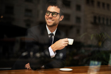 Handsome businessman enjoy in fresh coffee. Young man in suit drinking coffee in cafe