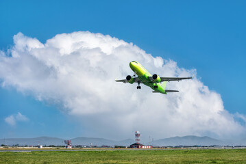 Fototapeta na wymiar A big yellow jet taking off on background of blue sky.