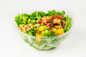 Poke bowl with chicken in a sweet sauce, salad leafs, edamame beans, chili paper, pineapple and peanuts on a white background.  Plastic tableware for delivery. Close up
