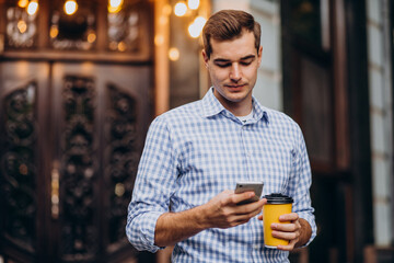 Young handsome man drinking coffee outside