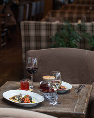 On the table in the restaurant serving for 2 persons. Dish with fish and eggplant, a glass teapot...