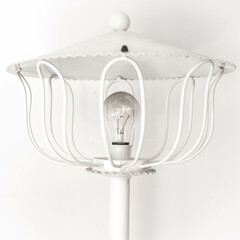 White forge vintage lamp with a modern light bulb. light turn off to save because of the high price of the electricity.