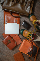 FlatLay still life set of vintage stylish leather items: brown shoes, a laptop, a notebook, two cases, a briefcase and a traveler's bag