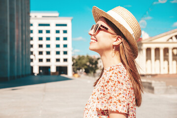 Young beautiful smiling hipster woman in trendy summer clothes. Sexy carefree woman posing on the street background at sunset. Positive model outdoors. Cheerful and happy in sunglasses and hat