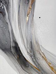 Abstract grey art with gold — black and white background with beautiful smudges and stains made with alcohol ink and golden paint. Grey fluid texture resembles marble, smoke, watercolor or aquarelle.
