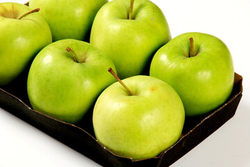 Six green apples in a packing box on a white background