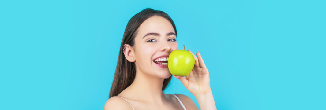 Portrait of young beautiful happy smiling woman with green apples. Healthy diet food. Stomatology concept. Woman with perfect smile holding apple, blue background. Woman eat green apple