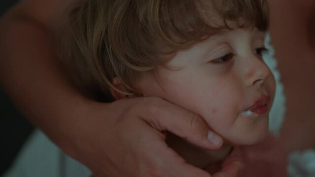 Mother brushing child teeth in evening routine before bed