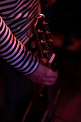 Man grabbing a guitar under neon lights