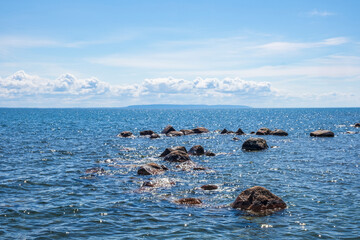 Fototapeta premium Lake view with a reef with sun sparkling water