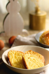Plate of traditional sweet bread, eaten at Easter time in Croatia. Easter bunny, eggs and flowers on the table. Selective focus.