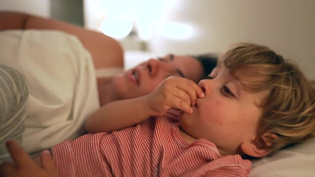 Mother telling bedtime story to little boy son