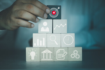 Businessman hand arranging wood block with icon business strategy and action plan