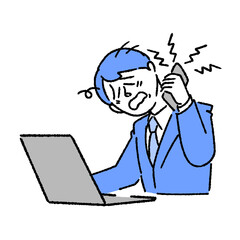 パソコンを見ながらクレーム処理の電話をするビジネスマン