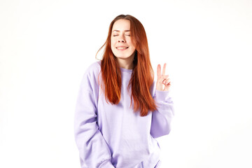 Fototapeta premium Caucasian woman in violet sweatshirt. Natural look. Smiling. long red hair. White background
