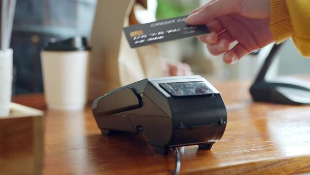 Customer using credit card for payment to owner at cafe restaurant, cashless technology and credit card payment concept