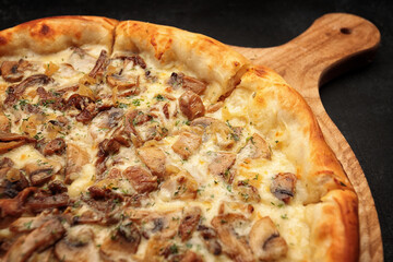 Pizza with mushrooms and cheese, on a wooden board