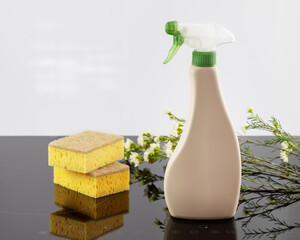 Mock up of organic cleaning products for house cleaning with sponges on a cooking panel with spring flowers. Eco friendly spring cleaning. Soft image and soft focus style. Mock up of stove cleaner