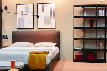 Double bed with white linen and shelving against the wall