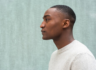 profile portrait handsome African american man against green background