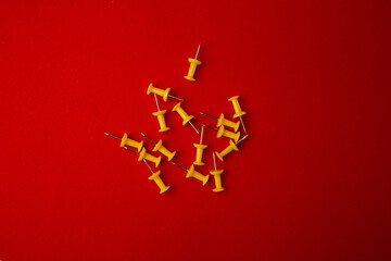 Yellow pushpins on a red background