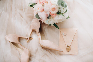bride's shoes with wedding rings on heels