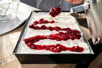Pour the cherry sauce over the cheesecake with a teaspoon, finishing the preparation of the...