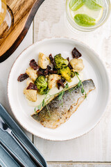 Grilled Sea bass with creamy lemon sauce and vegetables, cauliflower, broccoli, sun-dried tomatoes....