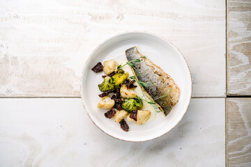 Sea bass with creamy lemon sauce and vegetables, cauliflower, broccoli, sun-dried tomatoes. top view