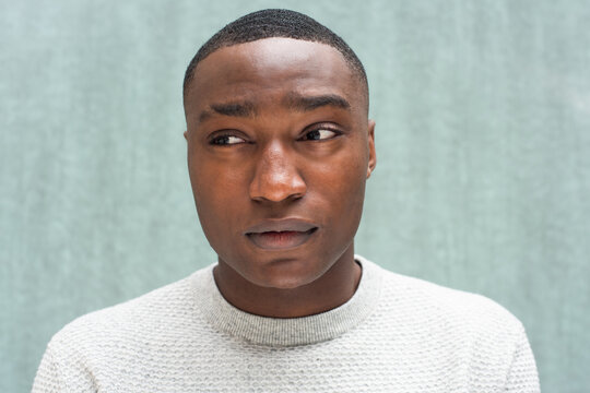 Close up African American man glancing by green background