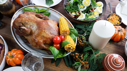 setting the table for a festive dinner in honor of Thanksgiving. on a wooden background there is a pumpkin garlic pepper and a dish with turkey and berry pie.festive lunch for the family