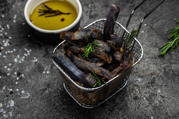 Sweet purple Potato Fries on dark background. Food recipe background. Delicious breakfast or snack, Clean eating, dieting, vegan food concept. top view