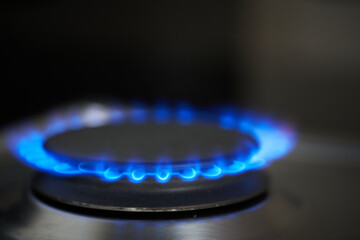 Modern kitchen stove cook with blue flames burning.