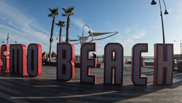 The big sign at Pismo Beach welcoming visitors on a bright sunny day - establishing shot