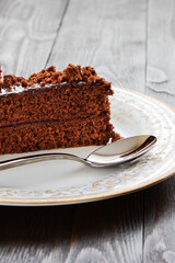 A piece of Chocolate cake on a plate on a wooden background.Slice of Homemade brownie cake.Copy space