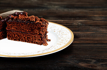 A piece of Chocolate cake on a plate on a wooden background.Slice of Homemade brownie cake.Copy space