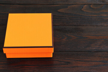 Orange gift box on a wooden background.Rustic box.Copy space