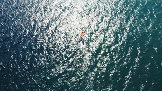 Aerial drone view of windsurfer enjoying on blue sea ocean waves.	
