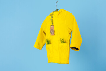 Rainwear recycling. used outerwear. Ecological and sustainable lifestyles. mock up yellow raincoat on a blue background. 