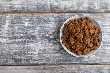 plate with unrefined cane sugar on gray wooden. top view, copy space.