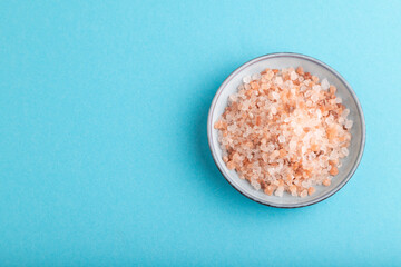 plate with pink Himalayan salt on blue pastel. top view, copy space.