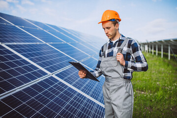 Man worker in the firld by the solar panels